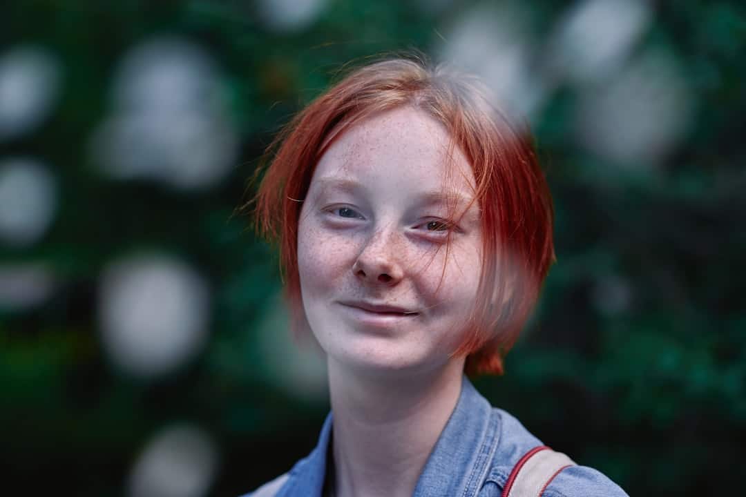 a woman with red hair is smiling for the camera