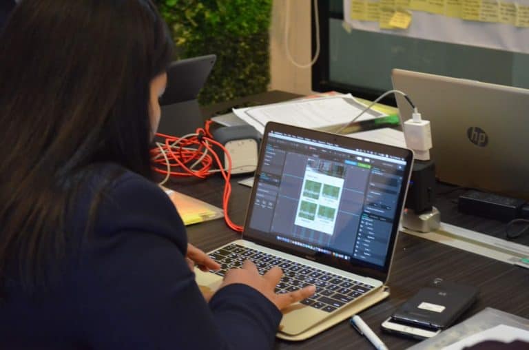 woman in black jacket using macbook pro